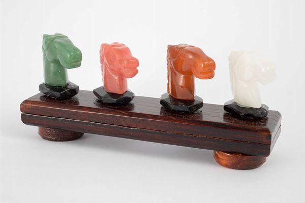 Group with four sculptures depicting heads of horses