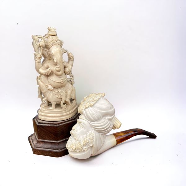 Coppia di oggetti in materiale plastico (pipa e Ganesha)