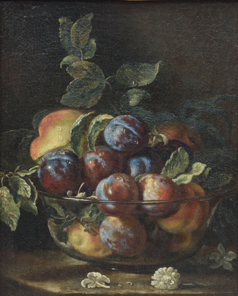 Composizione di frutta con pesche susine e una coppa in vetro