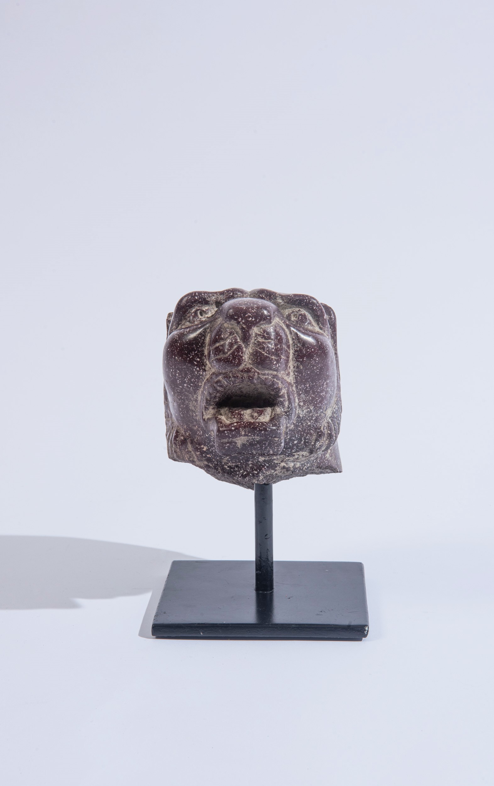 Frammento di scultura, testa felina in porfido rosso antico d'Egitto