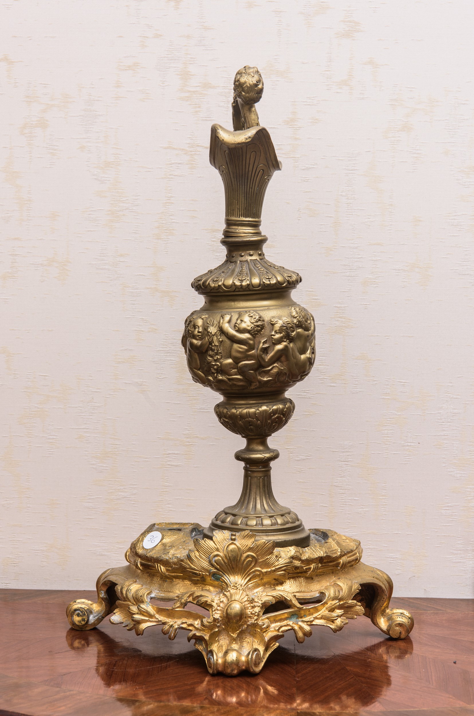 Versatoio in metallo dorato con putti e base rocaille in bronzo dorato