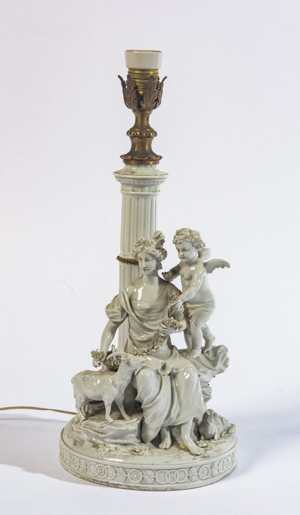 Scultura in porcellana raffigurante scena pastorale con figura femminile, putto e capretta