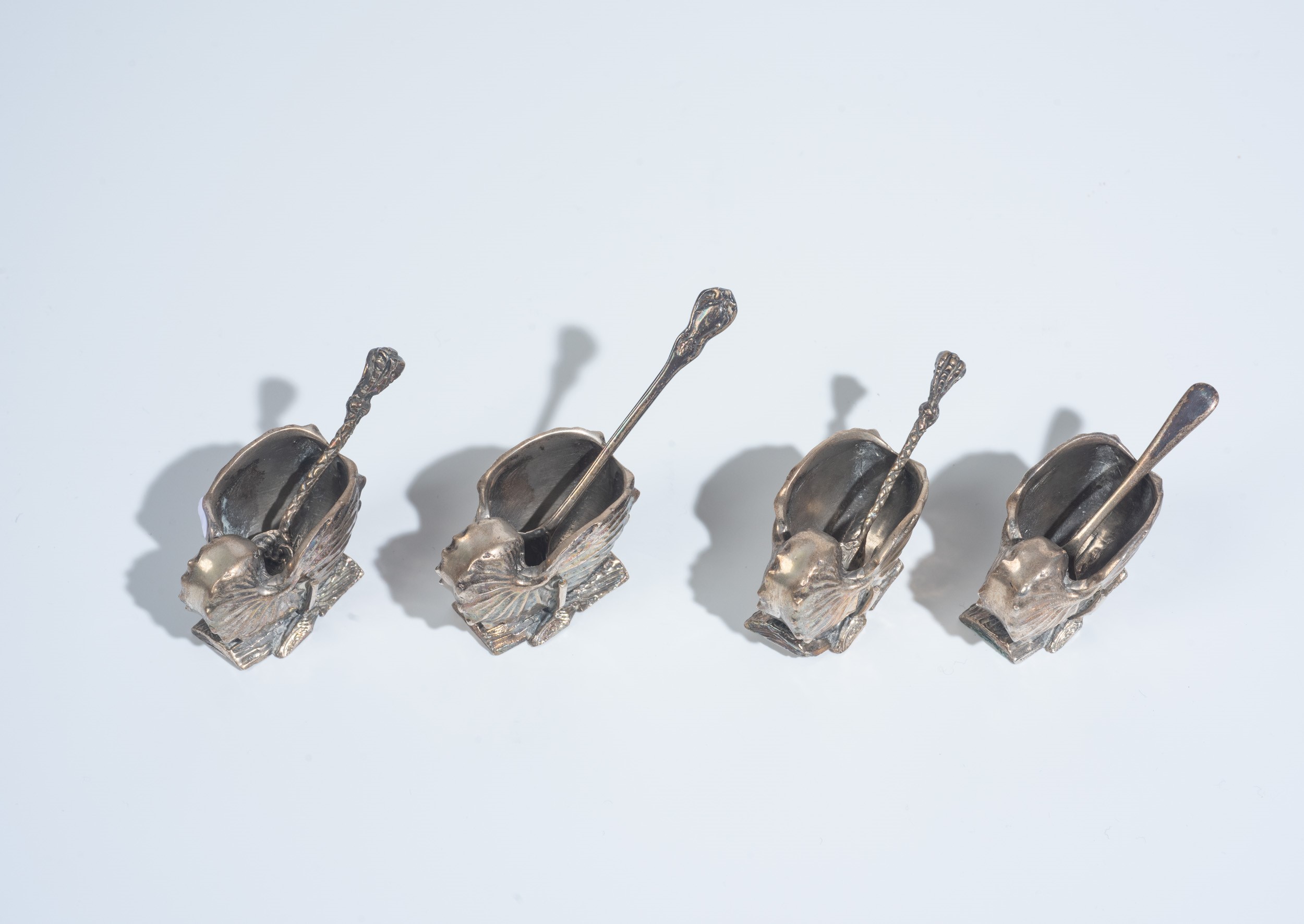 Set di quattro saliere in metallo argentato con quattro cucchiaini, XX secolo